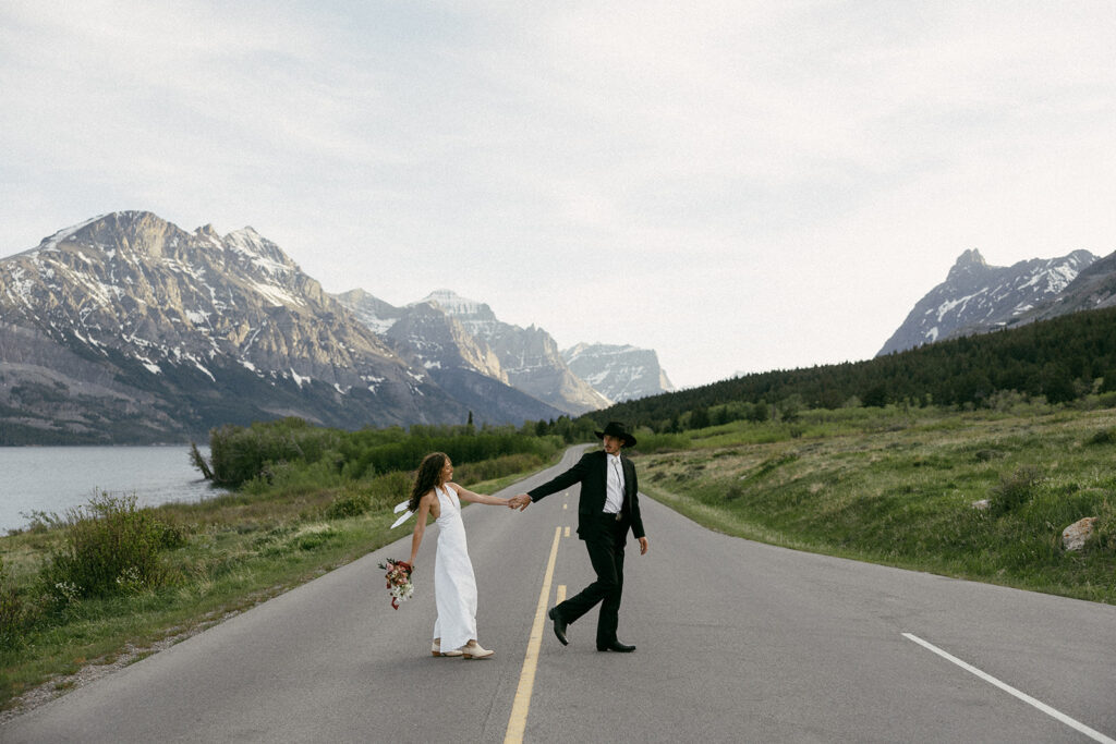 Bride and groom eloping in glacier national park in the middle of Going to the Sun Road