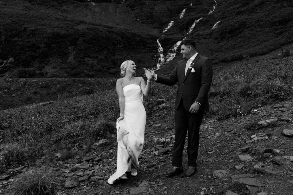 Bride and Groom laugh together after getting caught in the rain during their elopement in Glacier National Park