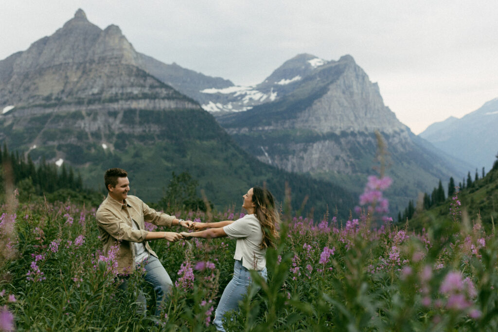 Couple dances together in Glacier National Park for their wildflower engagement session