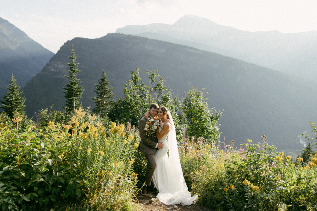 Wedding couple snuggle  up for photos on the side of the Going-To-The-Sun-Road 